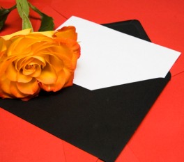 Yellow rose on top of card half in envelope